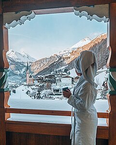 Frau im Bademantel am Balkon vom Hotel Kaiservilla im Winter - Link zu "Unterkünfte"
