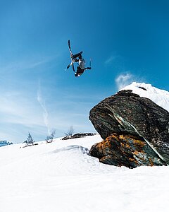 Freerider der Backflip von einem Felsen macht - Link zu "Skitickets"