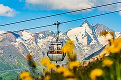 Bild von einer Gondel mit dem Großglockner im Hintergrund - Link zu "Öffnungszeiten"