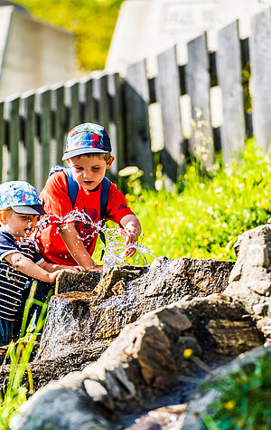 Zwei Kinder spielen beim Wasserspielplatz an der Mittelstation