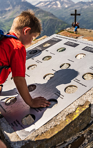 Kind beim Fühlen der verschiedenen Steine vom Naturgefahrentrail