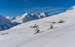 Zwei Skifahrer auf der Piste mit dem Großglockner im Hintergrund - Link zu FAQ Dynamic Pricing